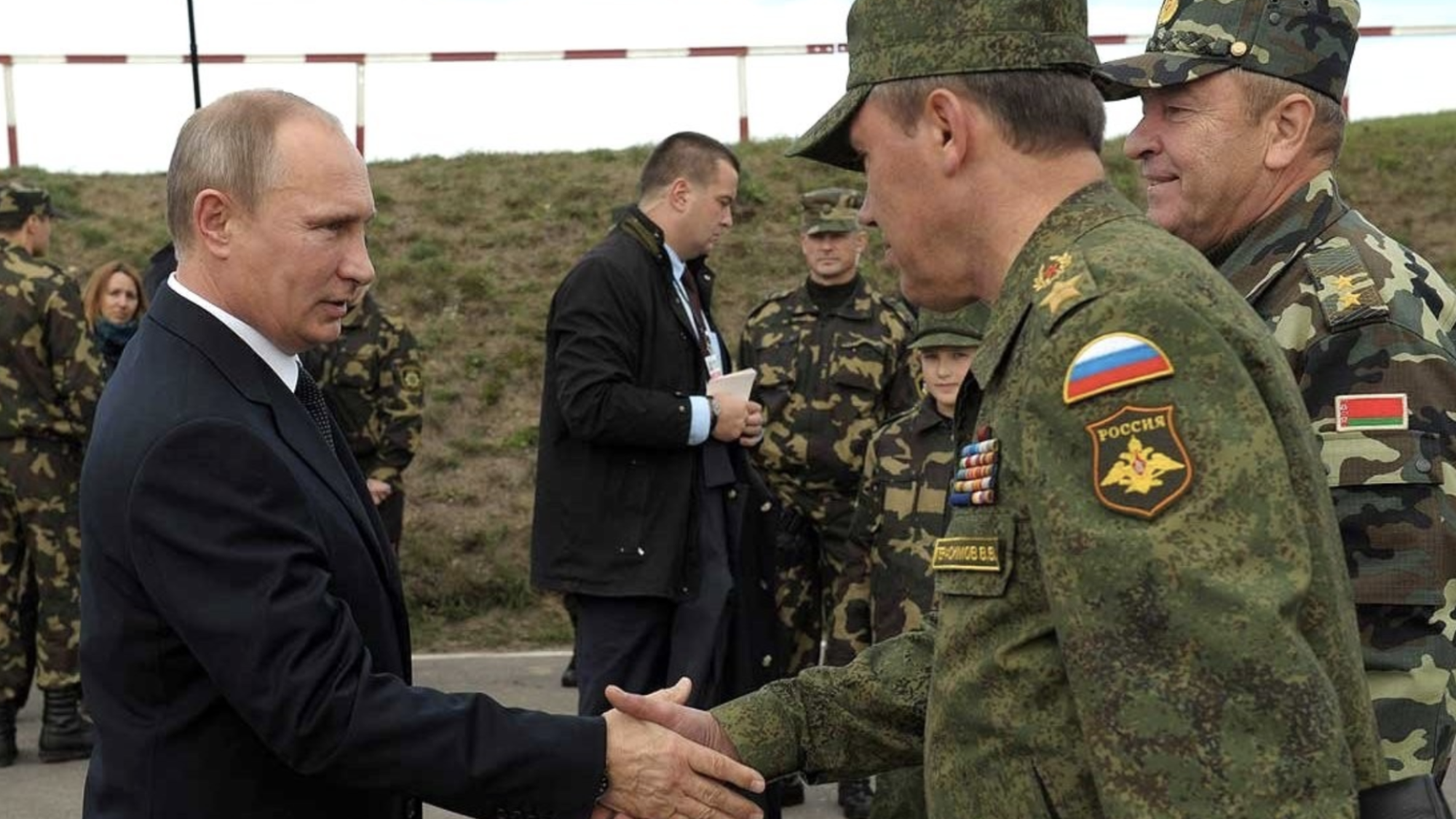 Vladimir Putin shakes the hand of a member of the Russian military.