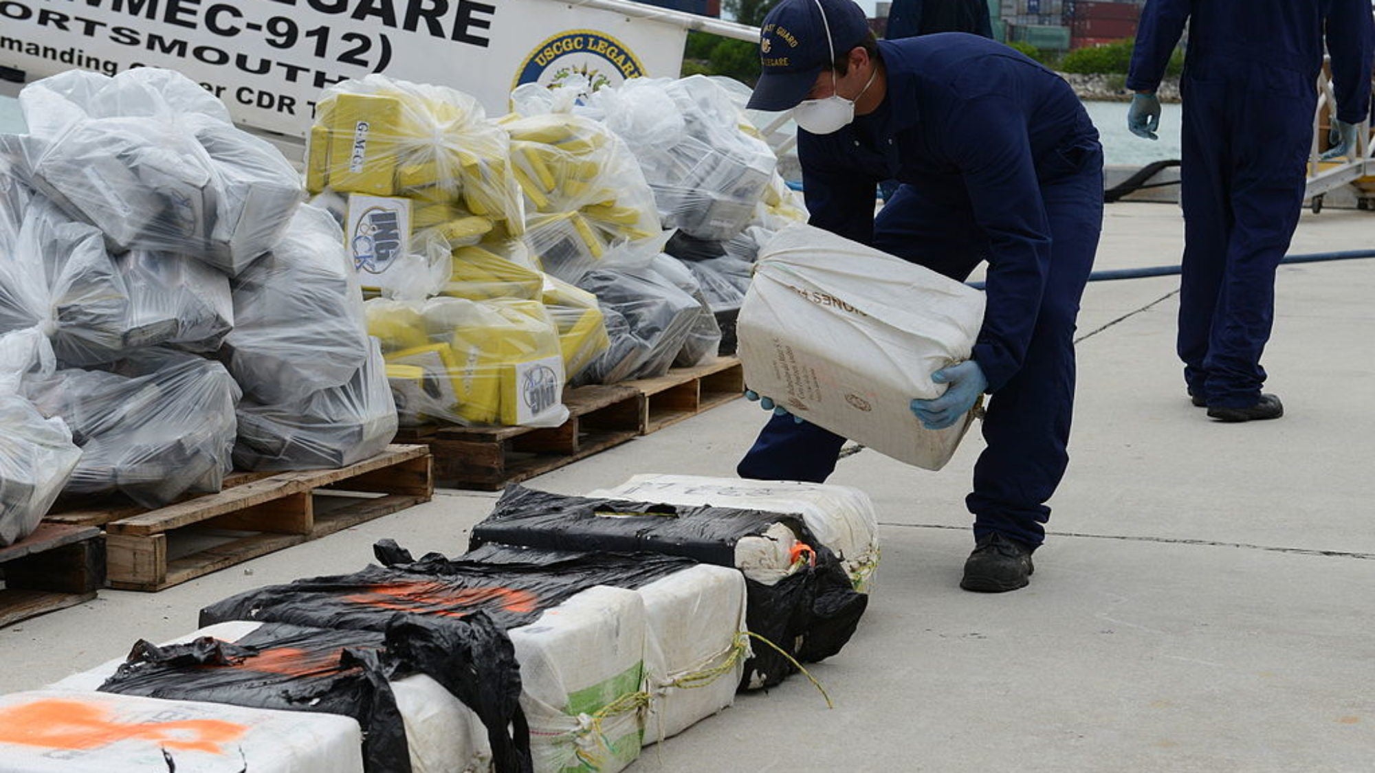 A U.S. Coast Guardsman assigned to the medium endurance cutter USCGC Legare (WMEC 912) stacks a bale of cocaine seized as part of Operation Martillo at Coast Guard Base Miami Beach, Fla.