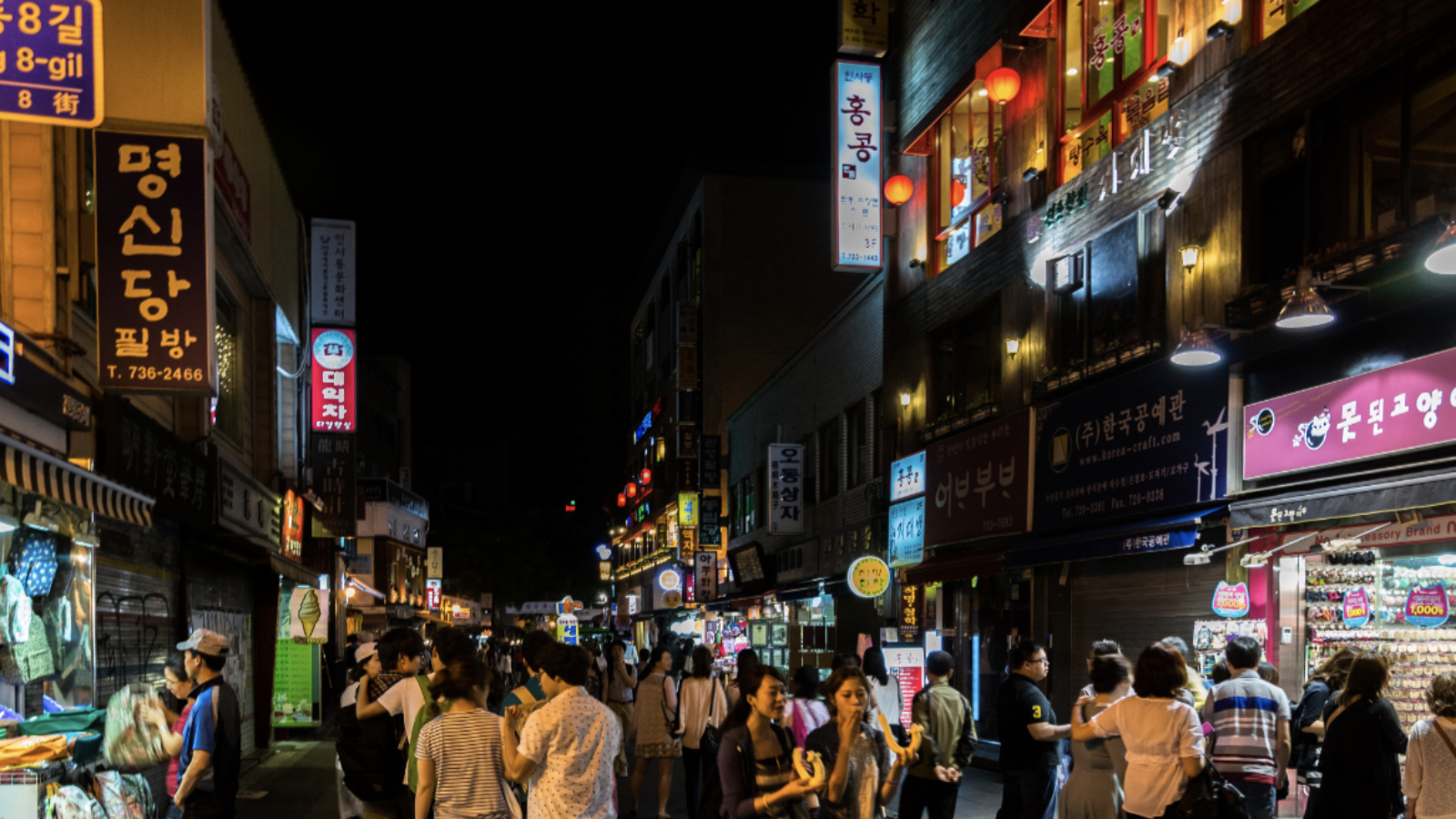 A busy city street at night in South Korea.