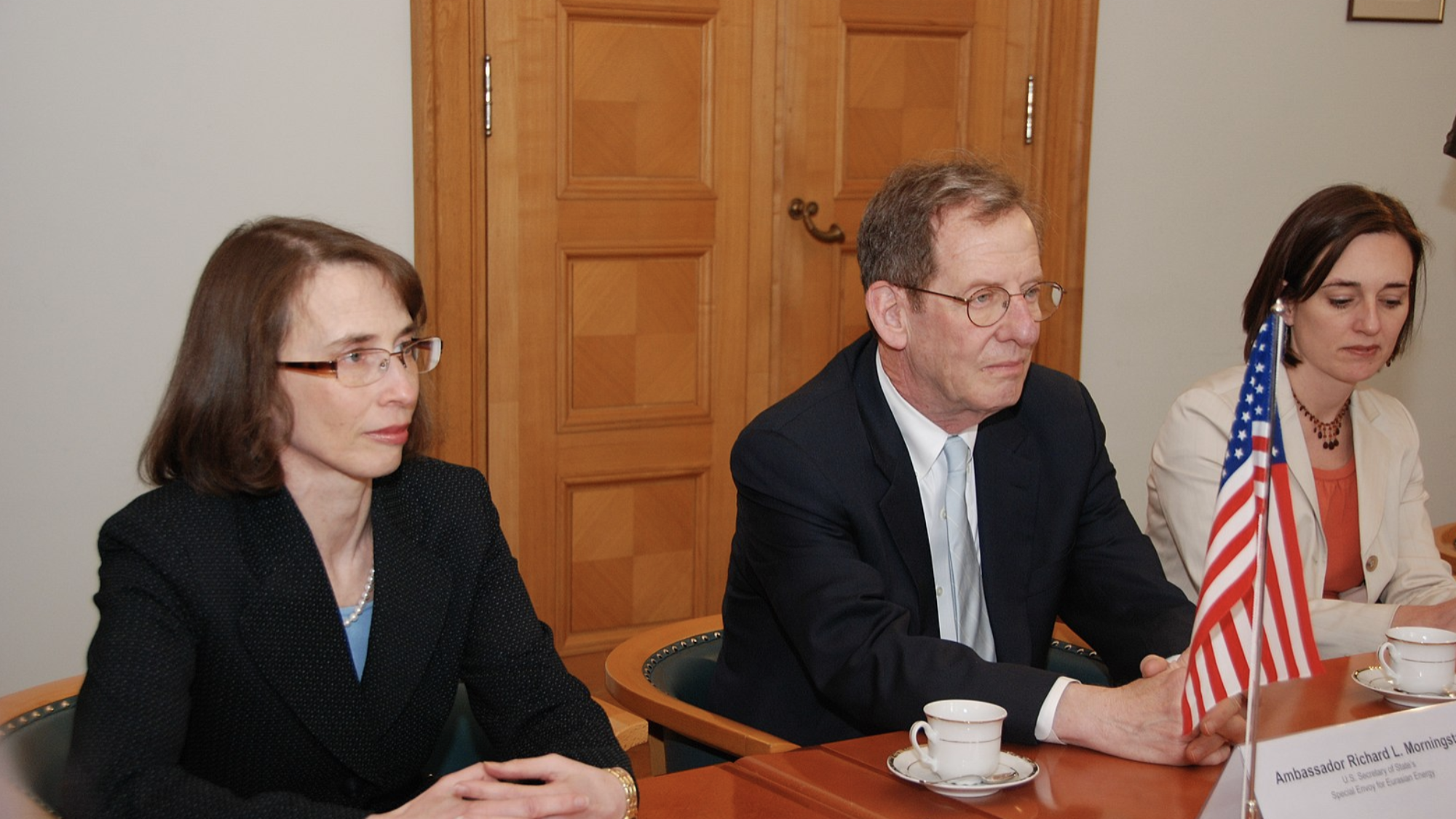 Ambassador Morningstar and another U.S. official sit behind a table with name placards and an American flag on it.