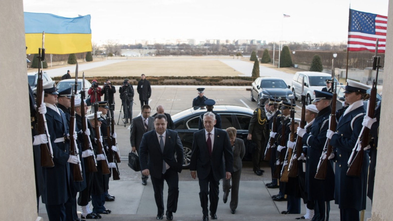 The U.S. and Ukranian Defense Secretaries walk up a set of stairs flanked by a row of U.S. soldiers.