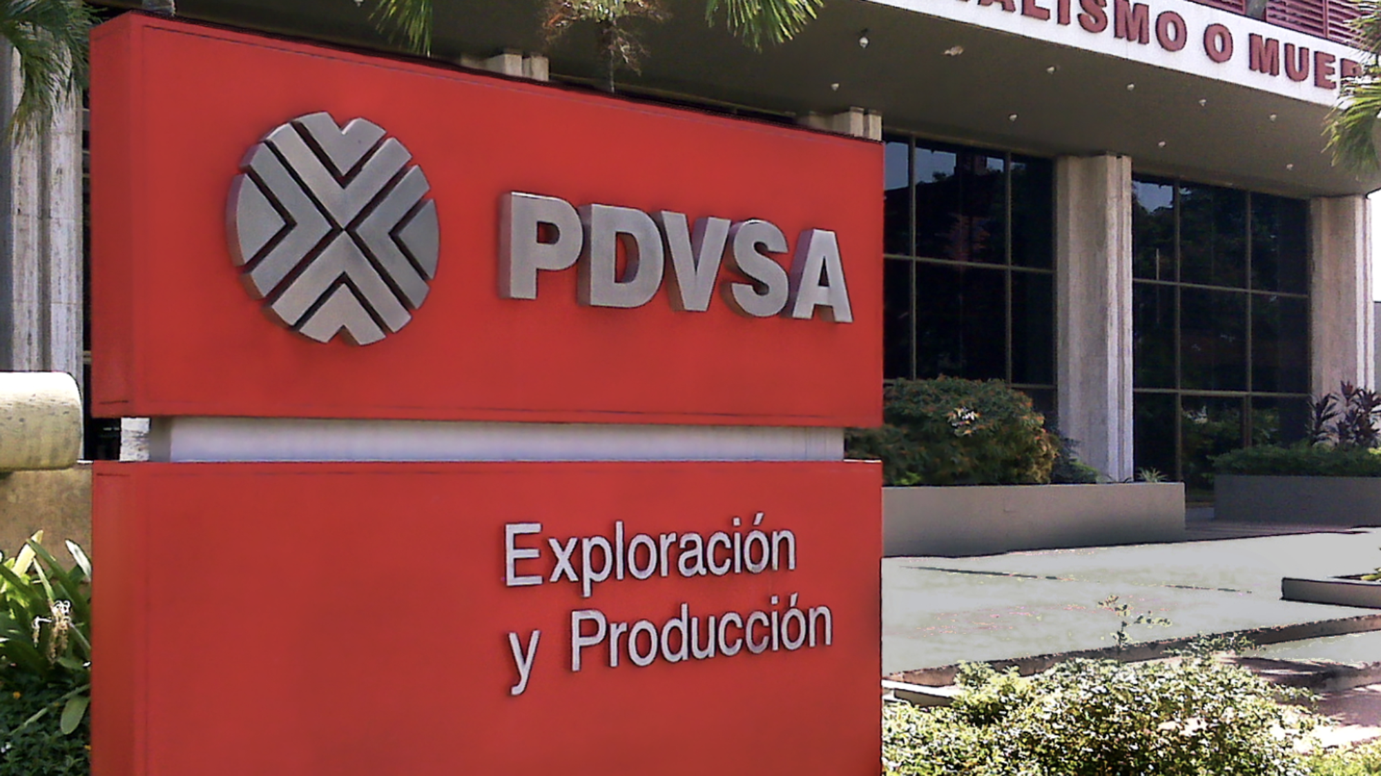 A red sign outside of a building says &quot;PDVSA: Exploracion y produccion.&quot;