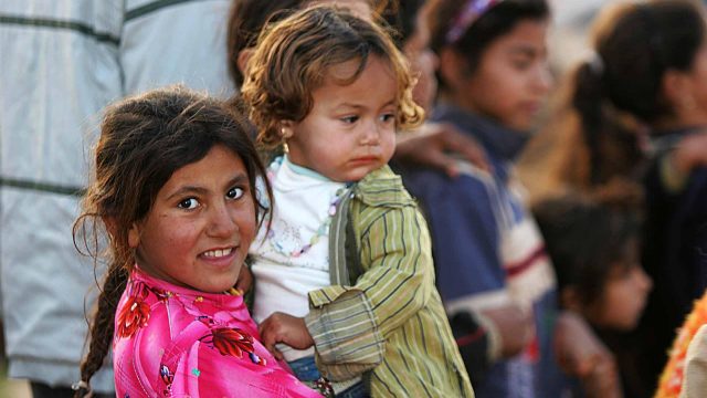 Young Iraqi refugee holding a young Iraqi refugee