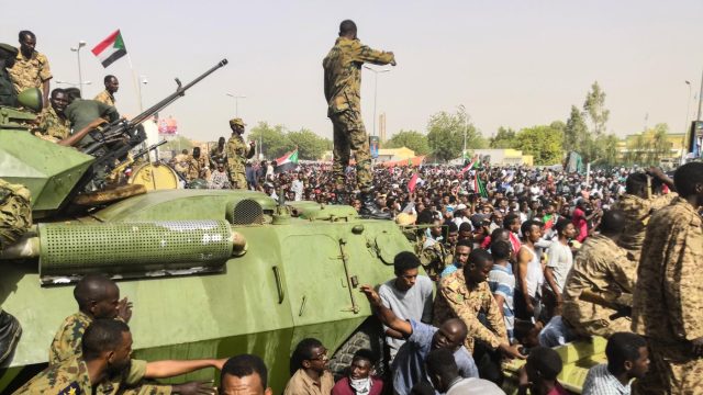 soldiers stand on tank in Sudan