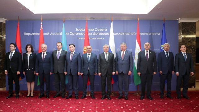 CSTO leaders posing in front of their flags at a meeting in Minsk