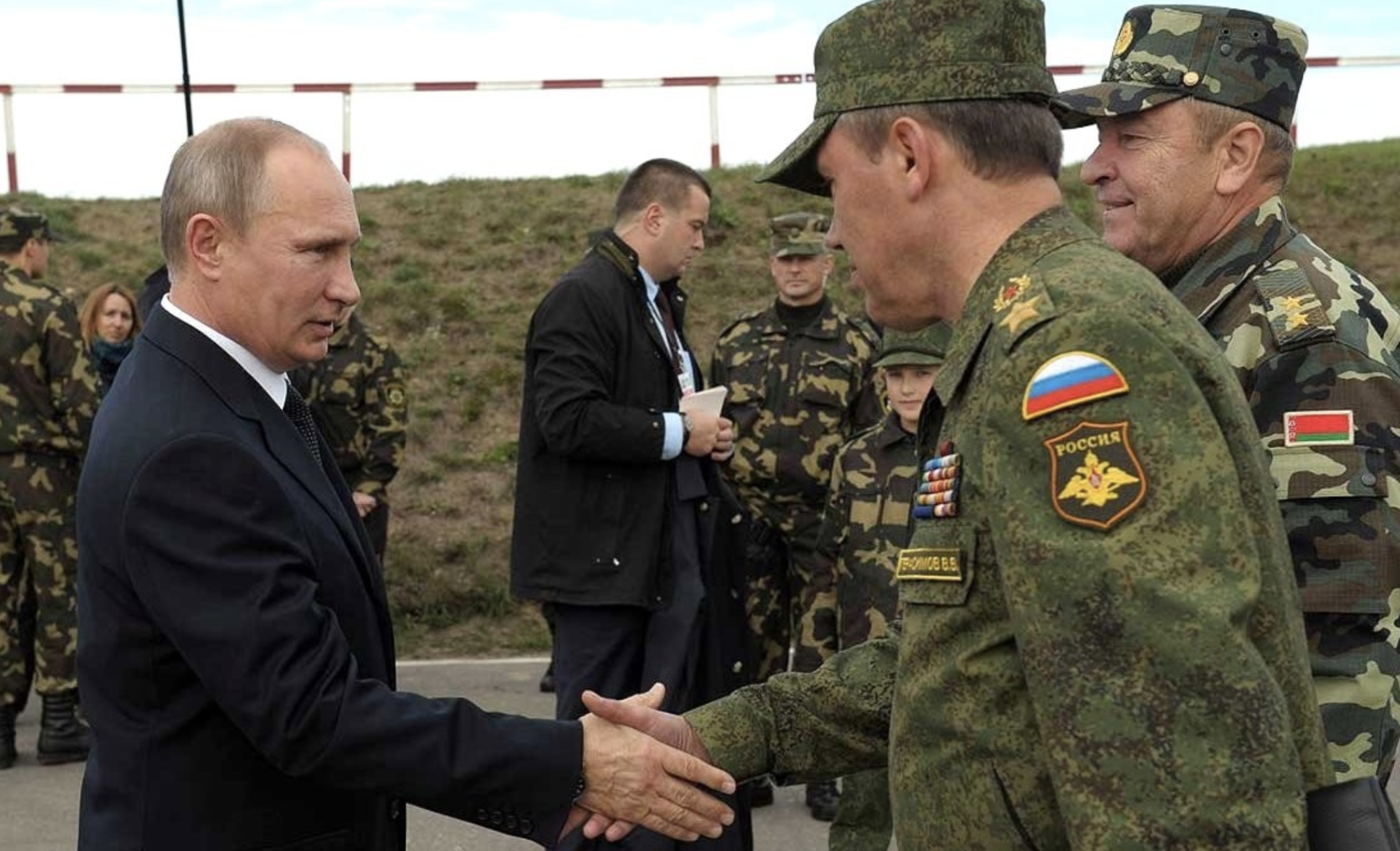 Vladimir Putin shakes the hand of a member of the Russian military.