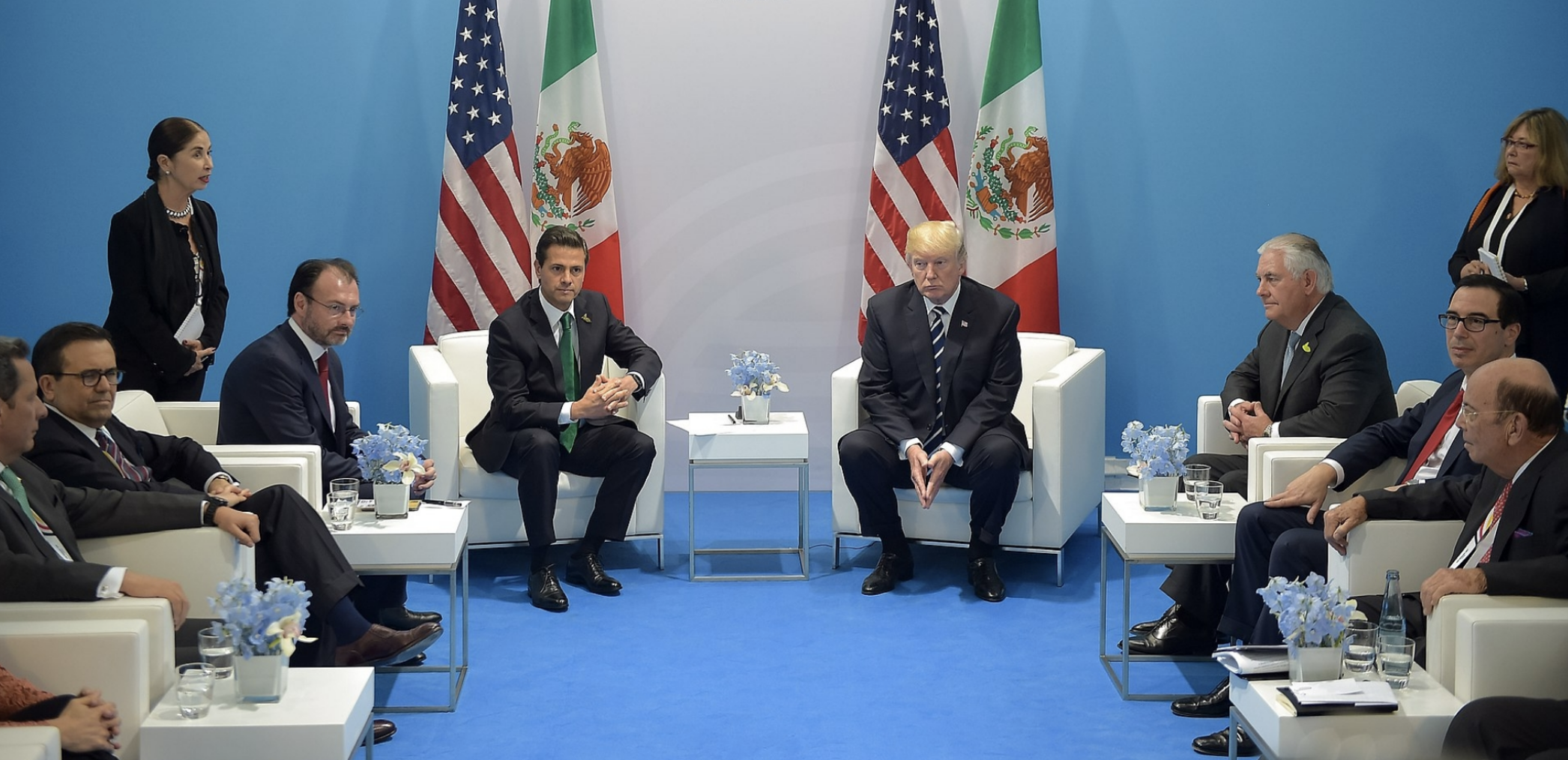 President Trump and President Enrique Peña Nieto sit next to each other in front of the U.S. and Mexican flags