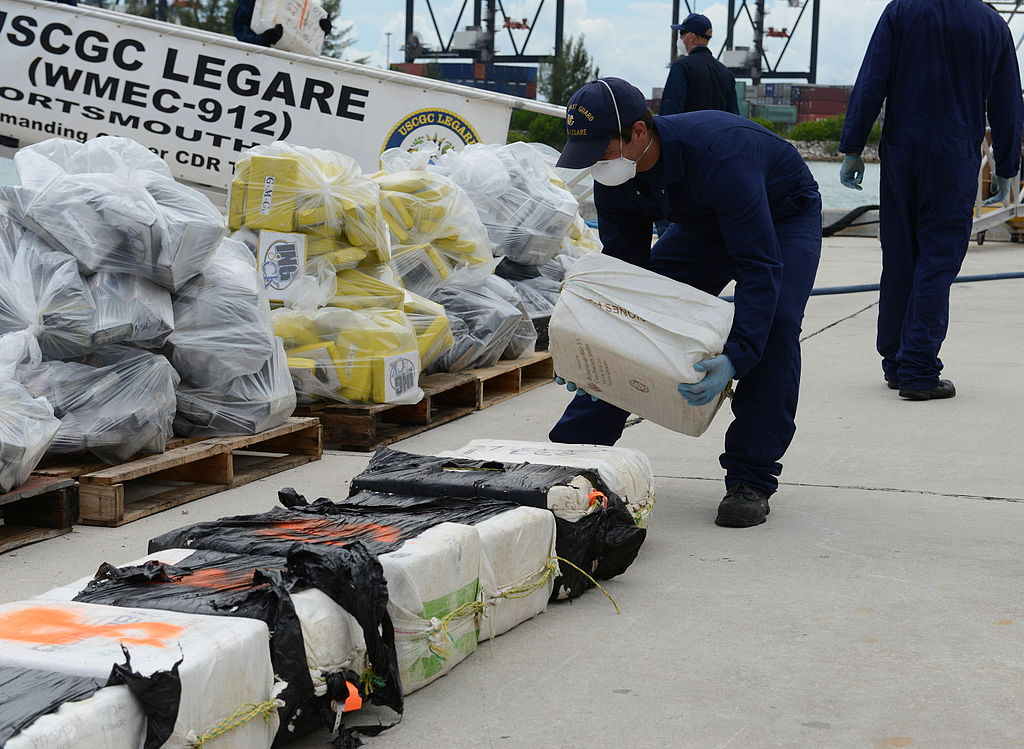 A U.S. Coast Guardsman assigned to the medium endurance cutter USCGC Legare (WMEC 912) stacks a bale of cocaine seized as part of Operation Martillo at Coast Guard Base Miami Beach, Fla.