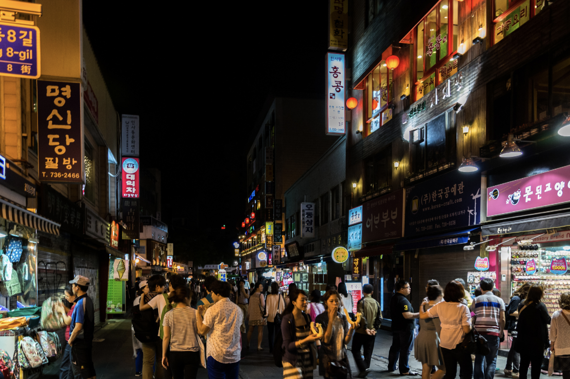 A busy city street at night in South Korea.