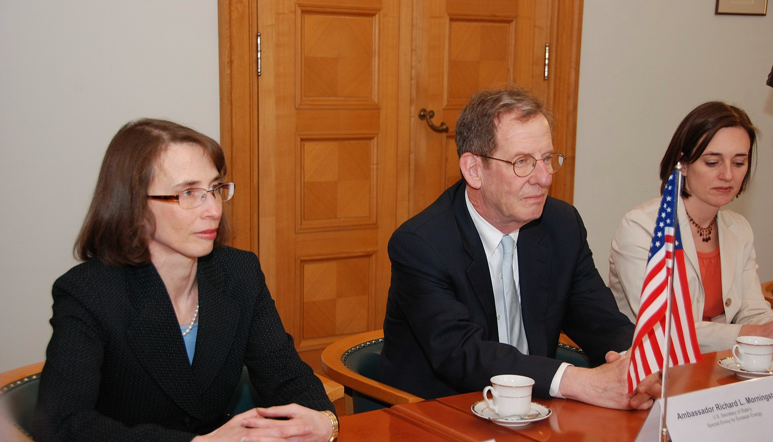 Ambassador Morningstar and another U.S. official sit behind a table with name placards and an American flag on it.