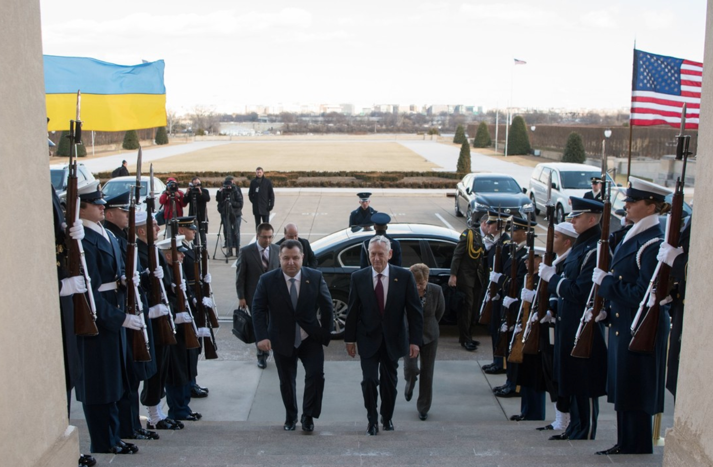 The U.S. and Ukranian Defense Secretaries walk up a set of stairs flanked by a row of U.S. soldiers.