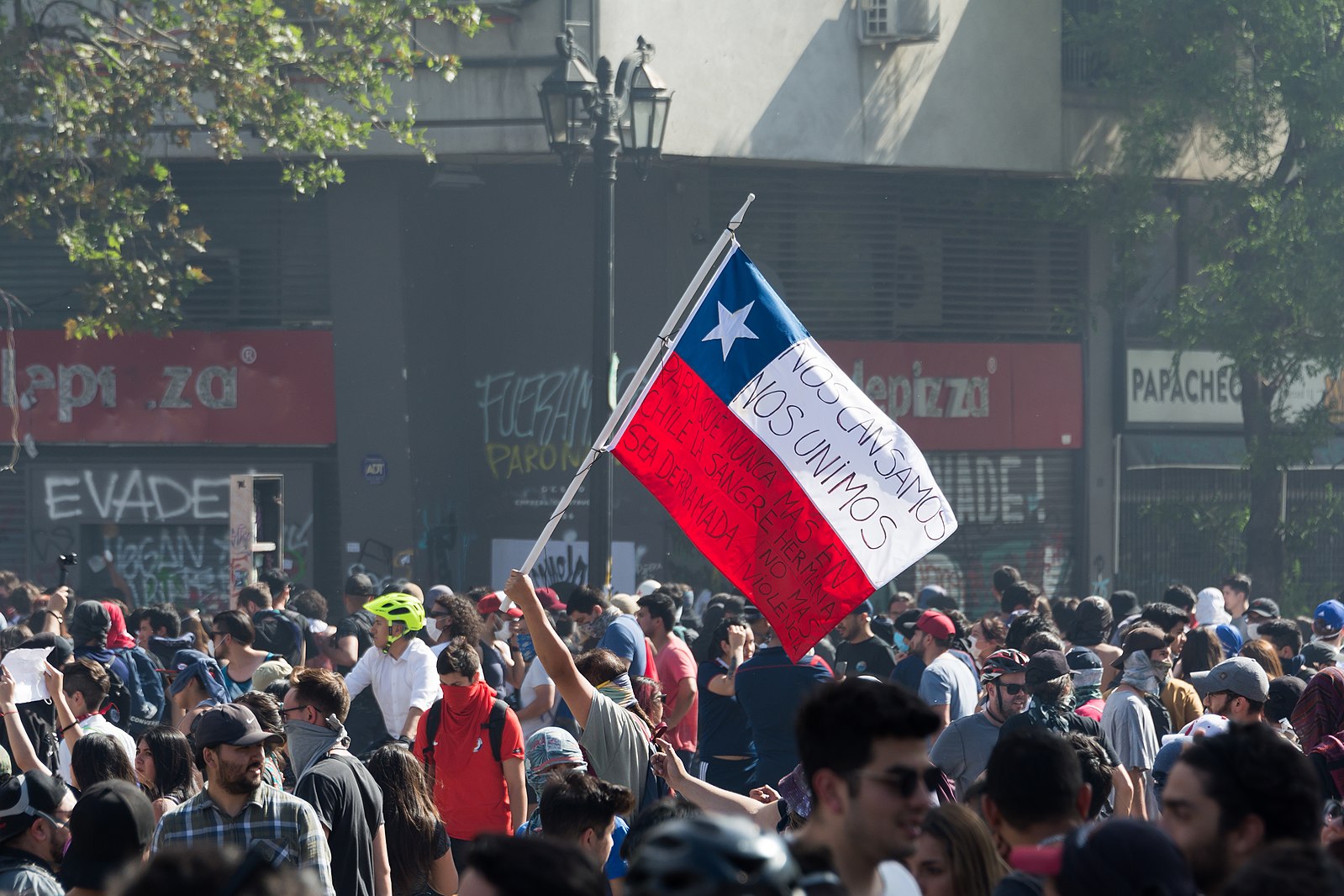 A Chilean flag is raised in the 2019 Protest in Santiago