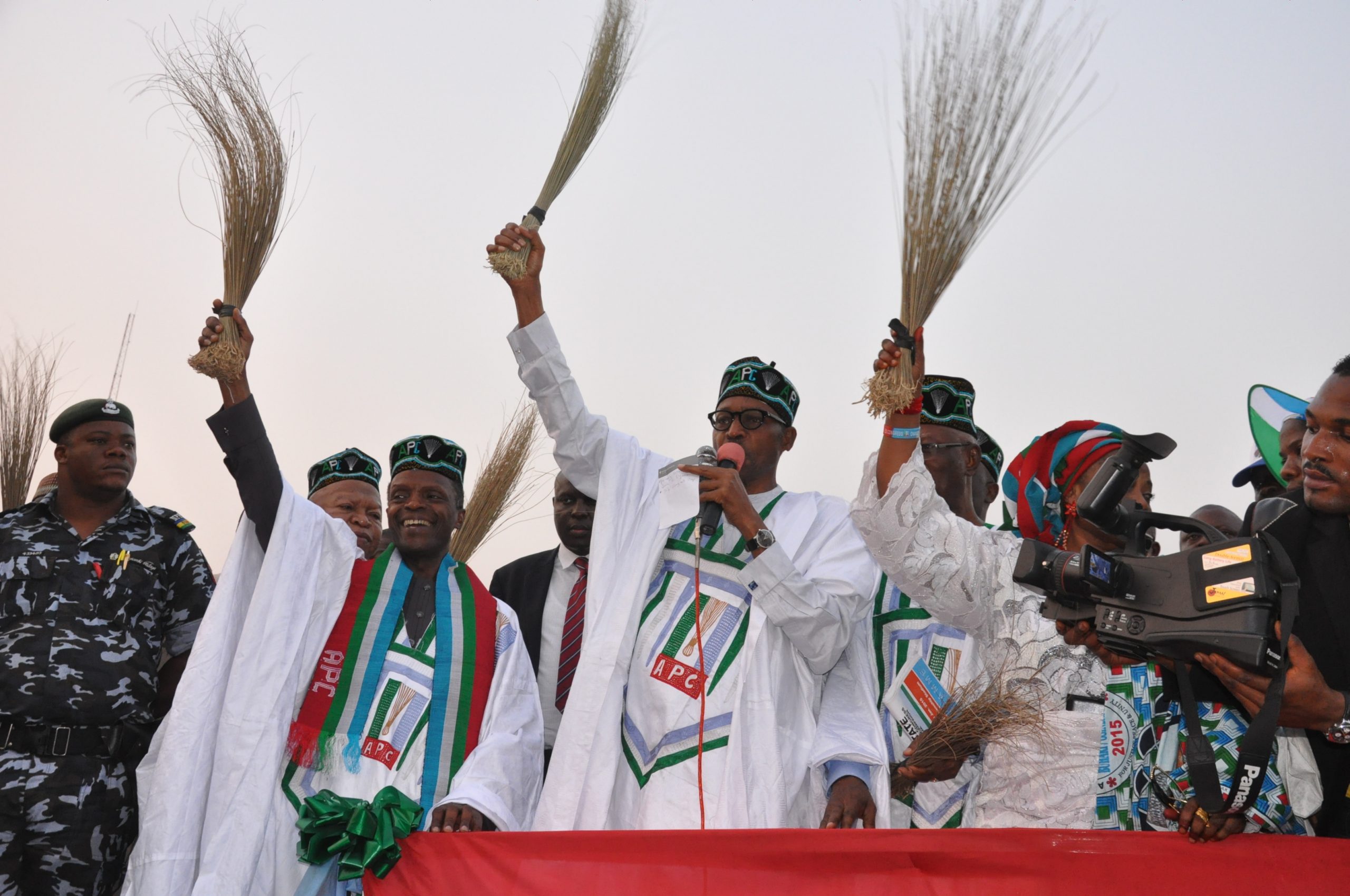 General Buhari holding a broom at a campign rally