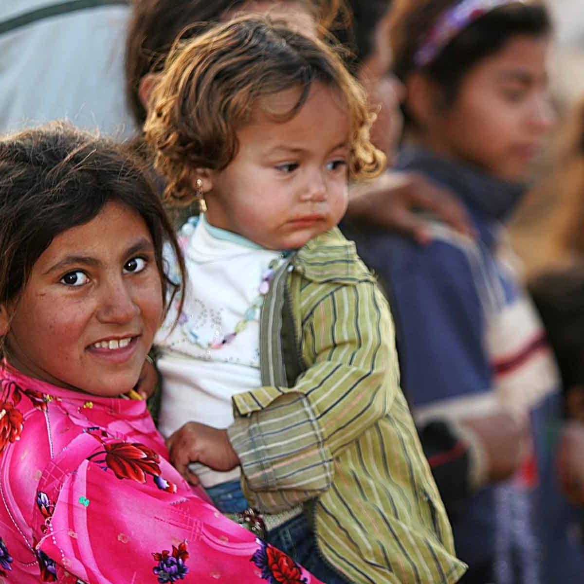 Young Iraqi refugee holding a young Iraqi refugee