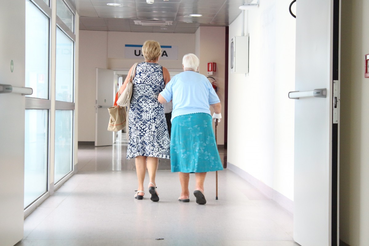Elderly women walk down a hospital corridor