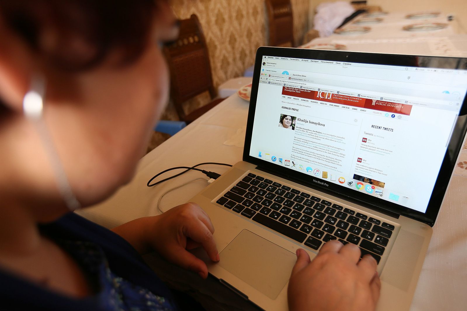 International Consortium of Investigative Journalists reporter sits at a laptop