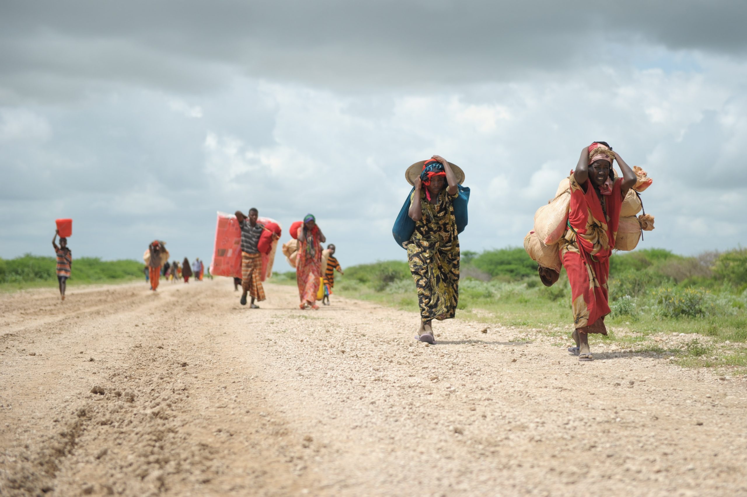 Women, walking with what possessions they can carry, arrive in a steady trickle at an IDP camp erected next to an AMISOM military base near the town of Jowhar, Somalia, on November 12. Heavy rains in Somalia, coupled with recent disputes between clans, has resulted in over four thousand IDPs seeking shelter at an AMISOM military base near the town of Jowhar, with more arriving daily.
